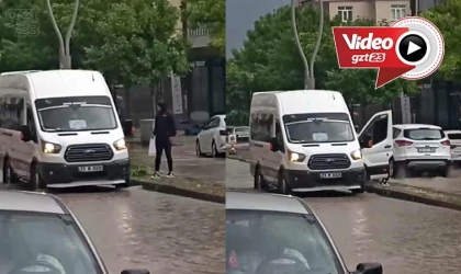 Yağmur sularının ortasında kalan yolcuyu, şoför kapısından içeri aldı